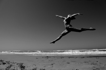 naked woman jumping on the beach