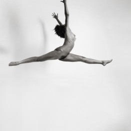 naked brunette jumping in the air with shadow