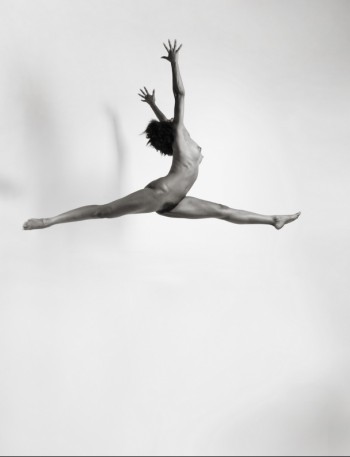 naked brunette jumping in the air with shadow