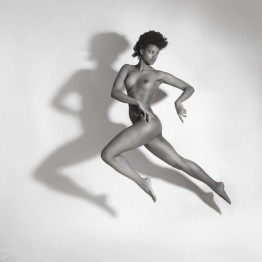 naked brunette jumping in the air with shadow