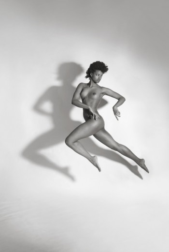 naked brunette jumping in the air with shadow