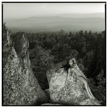 naked girl lying on a rock