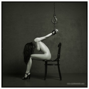 Fetish bondage picture of naked woman on chair with her hands tied