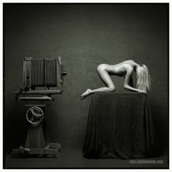 naked blonde woman in front of an old camera