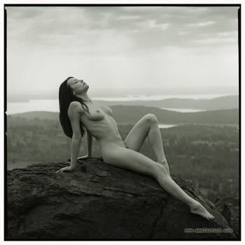 naked girl lying on a rock